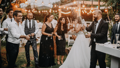 Une photo prise lors de l'ouverture de la bouteille de champagne lors d'un mariage, on peut y voir la et le mariés ainsi que les invités autour d'eux entrain de célébrer leur union. - Cowoliday