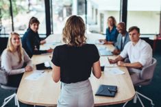 Une femme professionnel de dos faisant une formation professionnelle à son équipe de collaborateurs - Cowoliday