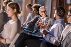 Un image qui fait un focus sur un moment de cohésion d'équipe lors d'un séminaire, ici on zoom sur un femme et un homme discutant dans des rangs auditoire - cowoliday