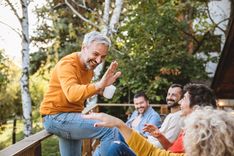 Un groupe de personnes améliorant leur cohésion lors d'un séjour en groupe, on voit un homme tapé dans la main de ses coéquipiers, il peut s'agir ici d'une activité lors d'un team building ou séminaire - Cowoliday