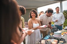 Couple célébrant un gender reveal avec amis et famille en coupant un gâteau qui annonce le sexe du futur bébé - Cowoliday