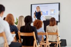 Présentation professionnel, ou on voit une femme sur une estrade entrain de présenter un lancement de produit à une audience à l'écoute - Cowoliday