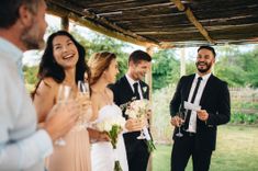 image ou on peut voir plusieurs personnes à un mariage, la mariée est visible et tout le monde sirote une coupe de champagne, l'ambiance est légère et festive - Cowoliday